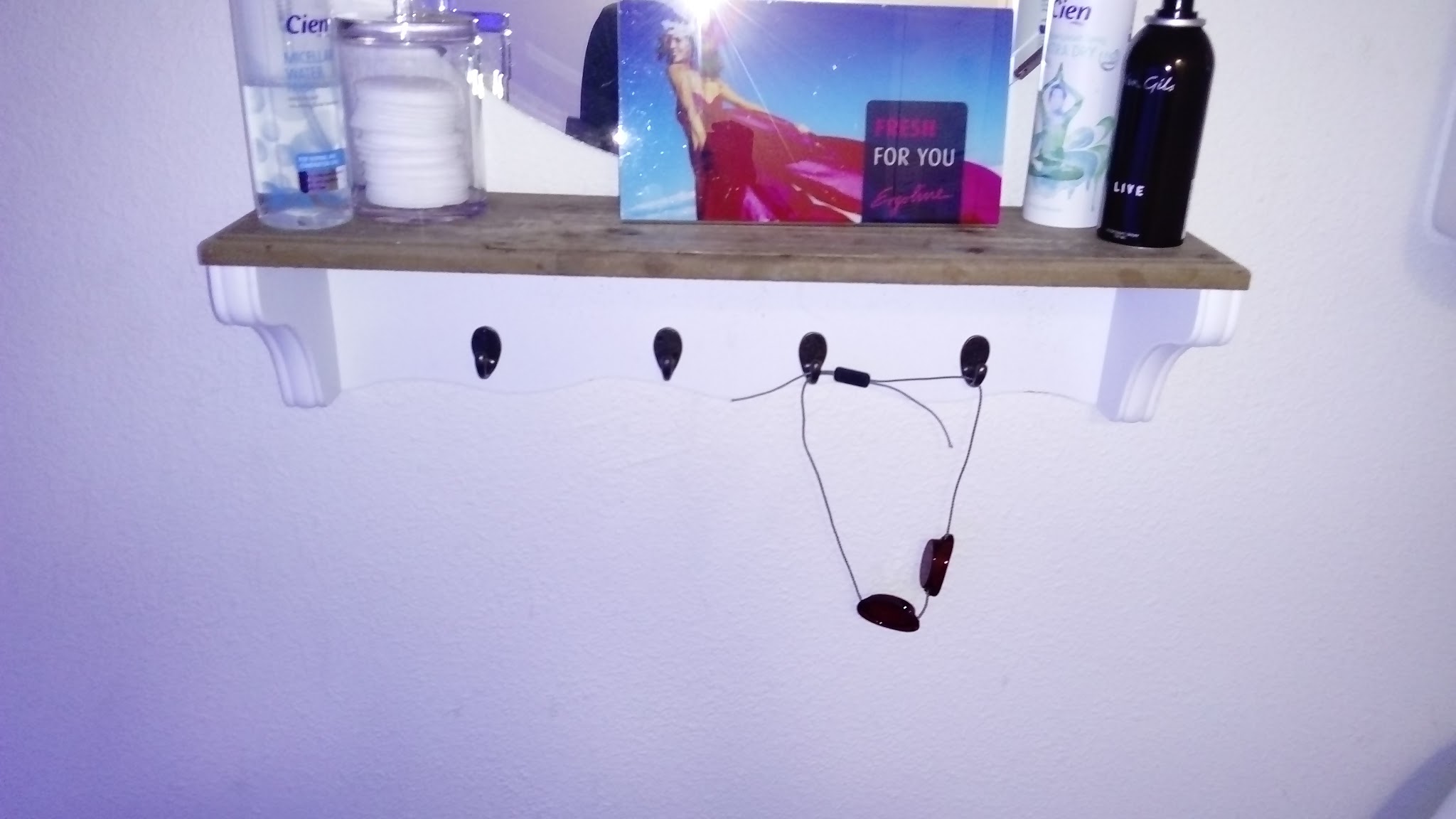 Een plank in de cabine met verzorgingsproducten en de uv-bril aan een haakje
